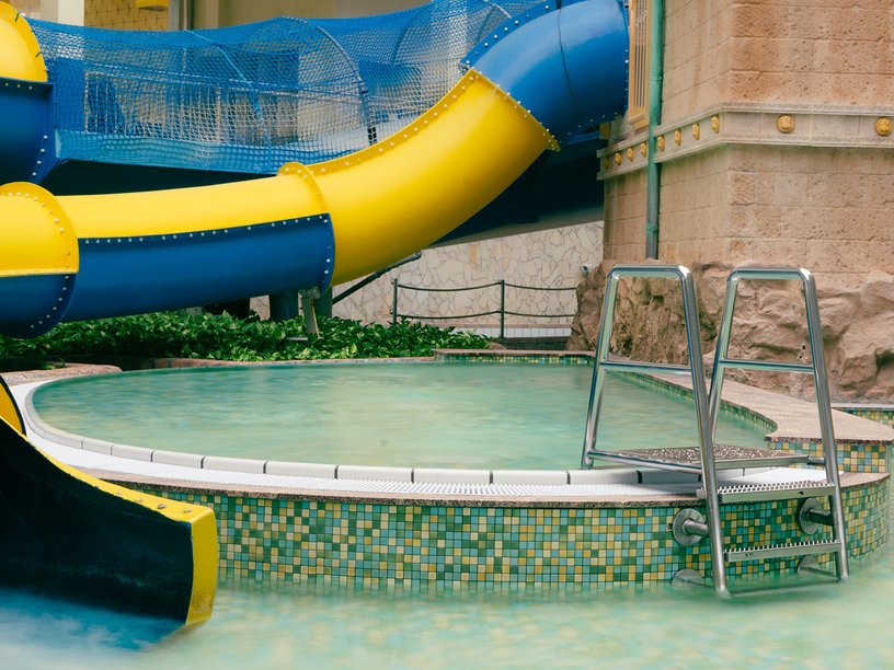 Wärmebecken für Kinder im Hintergrund die Drachenrutsche