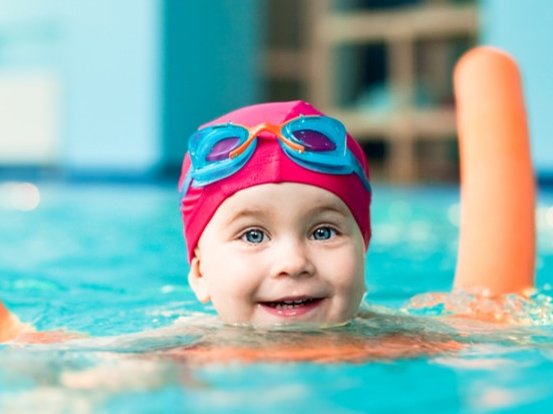  Kind mit Schwimmnudel im Wasser