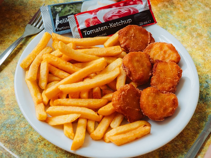 Esssen im Bistro es gibt Pommes und Chicken wings dazu ketchup und mayonnaise
